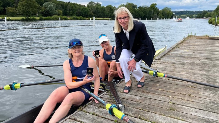 Woman presenting medals to women's Mas F 2x