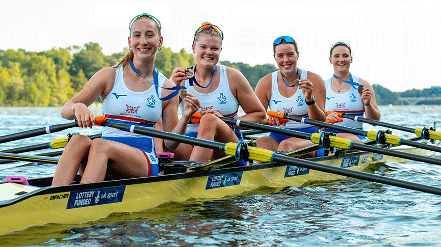 4 women in boat with bronze medals