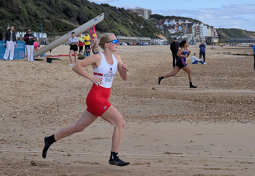 Junior beach sprint sculler sprinting down beach