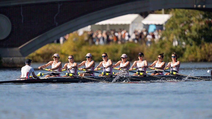 Women's eight racing towards bridge