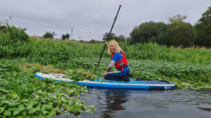 Woman on SUP by Floating Pennywort